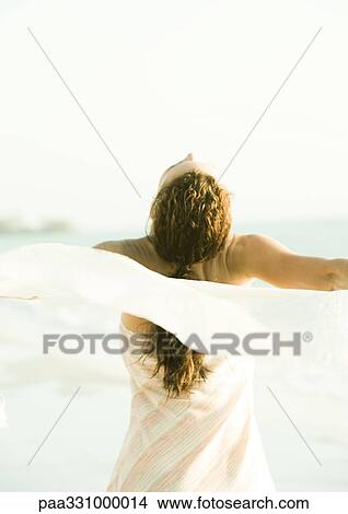 Picture - Woman throwing head back and spinning around with scarf in wind. Fotosearch