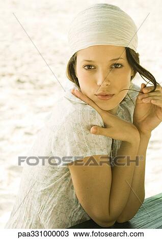 Stock Image - Woman wearing headscarf on beach, portrait. Fotosearch