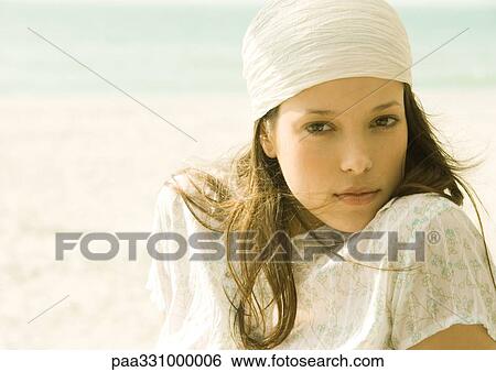 Stock Photograph - Woman wearing headscarf on beach, portrait. Fotosearch