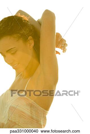 Stock Image - Woman with arms crossed behind head. Fotosearch