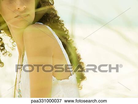 Woman with long curly hair, dune grass blurred in foreground View Large Photo Image Stock Photo - Woman with long curly hair, dune grass blurred in foreground. Fotosearch