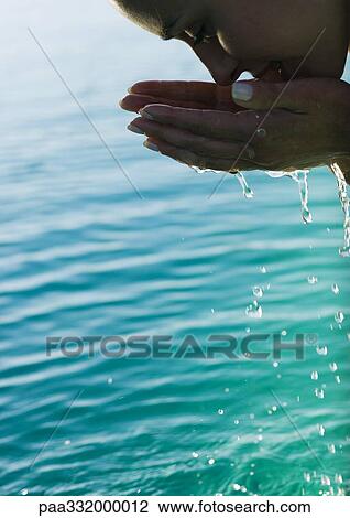 Woman leaning over water, cupping water to face View Large Photo Image Stock Image - Woman leaning over water, cupping water to face. Fotosearch