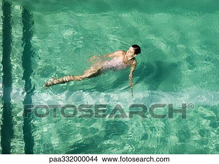 Woman swimming in pool, full length View Large Photo Image Picture - Woman swimming in pool, full length. Fotosearch