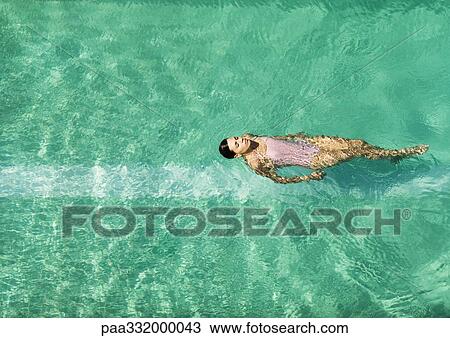 Woman swimming in pool, full length View Large Photo Image Stock Image - Woman swimming in pool, full length. Fotosearch