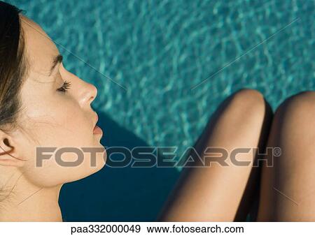 Woman's face and legs seen over pool water, high angle view View Large Photo Image Stock Photo - Woman's face and legs seen over pool water, high angle view. Fotosearch