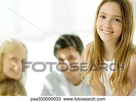 Girl, parents in background View Large Photo Image Stock Image - Girl, parents in background. Fotosearch