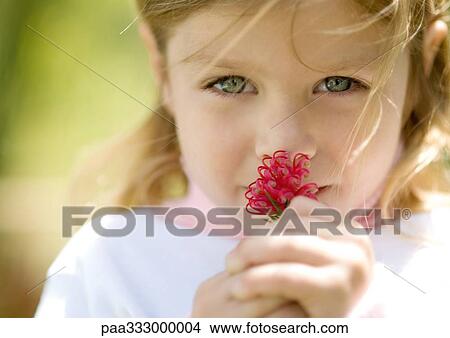 Picture - Girl smelling flower. Fotosearch