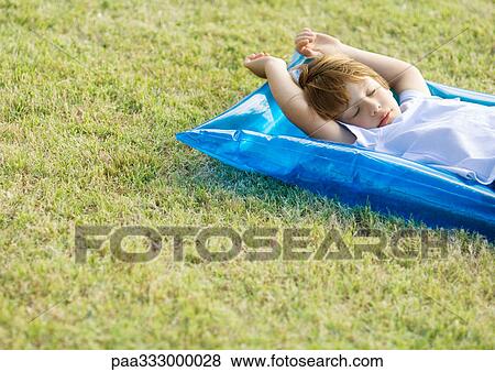 Little boy sleeping on inflatable raft, on grass View Large Photo Image Stock Photo - Little boy sleeping on inflatable raft, on grass. Fotosearch