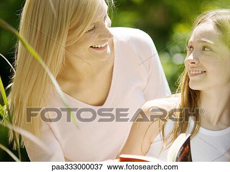 Stock Photo - Mother and daughter smiling at each other. Fotosearch
