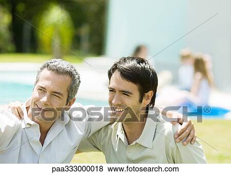 Two men with arms around each other's shoulders, smiling View Large Photo Image Stock Photo - Two men with arms around each other's shoulders, smiling. Fotosearch