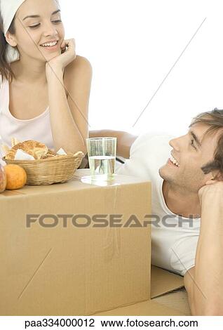 Couple having breakfast on cardboard box View Large Photo Image Stock Image - Couple having breakfast on cardboard box. Fotosearch
