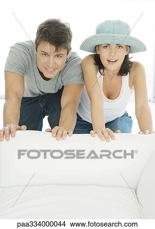 Couple moving armchair together View Large Photo Image Picture - Couple moving armchair together. Fotosearch
