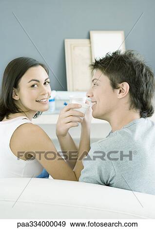 Couple sitting with arms linked, about to drink View Large Photo Image Stock Photo - Couple sitting with arms linked, about to drink. Fotosearch