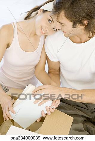 Couple unpacking cardboard box View Large Photo Image Stock Photo - Couple unpacking cardboard box. Fotosearch