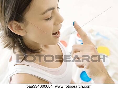 Picture - Man's finger reaching towards woman's nose with drop of paint. Fotosearch