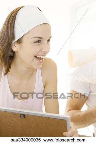 Stock Photograph - Woman holding frame, laughing. Fotosearch