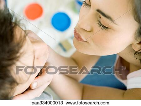 Woman holding man's face and puckering lips for a kiss, high angle view View Large Photo Image Stock Image - Woman holding man's face and puckering lips for a kiss, high angle view. Fotosearch