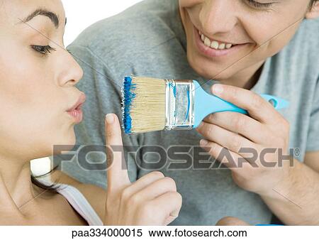 Woman holding up finger in front of paintbrush held by man View Large Photo Image Stock Photography - Woman holding up finger in front of paintbrush held by man. Fotosearch