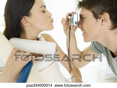 Woman puckering lips as man takes her photo View Large Photo Image Picture - Woman puckering lips as man takes her photo. Fotosearch