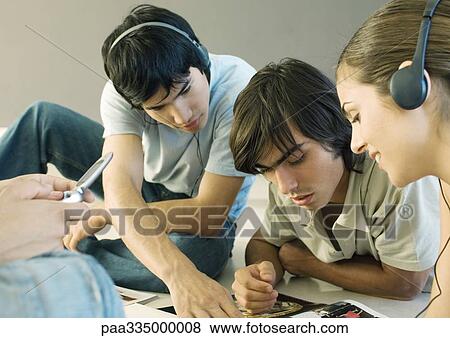 Stock Photo - Group of friends with headphones and cell phone. Fotosearch