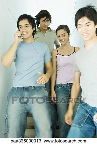 Stock Image - Group of young adult friends going down stairs together. Fotosearch