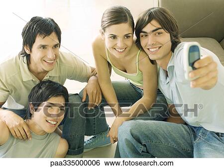 Stock Photograph - Taking group photo with cell phone. Fotosearch