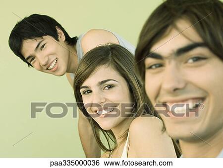 Three young adult friends smiling View Large Photo Image Stock Photograph - Three young adult friends smiling. Fotosearch