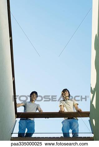 Two young male friends, low angle view View Large Photo Image Stock Photography - Two young male friends, low angle view. Fotosearch