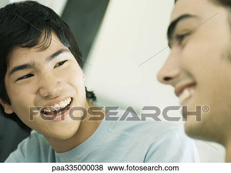 Two young men smiling View Large Photo Image Stock Photo - Two young men smiling. Fotosearch