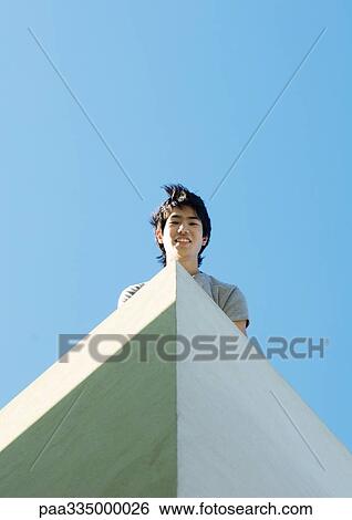 Young man, low angle view View Large Photo Image Stock Photograph - Young man, low angle view. Fotosearch