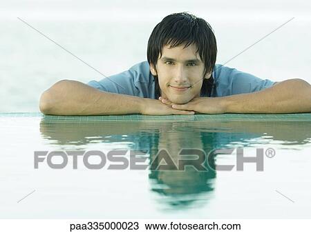 Young man resting head on hands near edge of water, portrait View Large Photo Image Stock Image - Young man resting head on hands near edge of water, portrait. Fotosearch