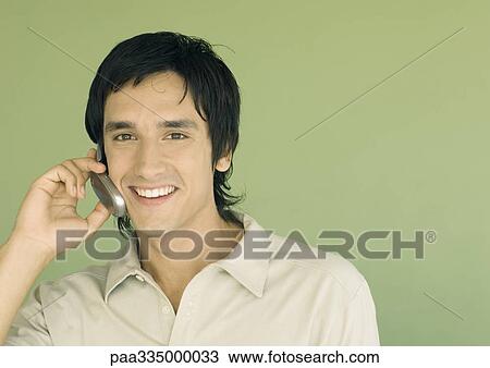 Stock Image - Young man using cell phone. Fotosearch