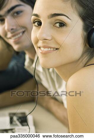 Stock Photograph - Young woman listening to headphones. Fotosearch