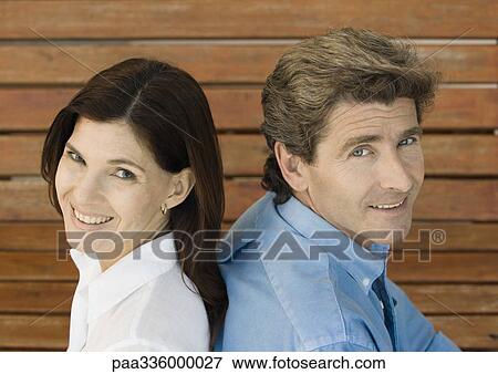 Couple back to back, smiling and looking at camera, portrait, close-up View Large Photo Image Stock Photo - Couple back to back, smiling and looking at camera, portrait, close-up. Fotosearch