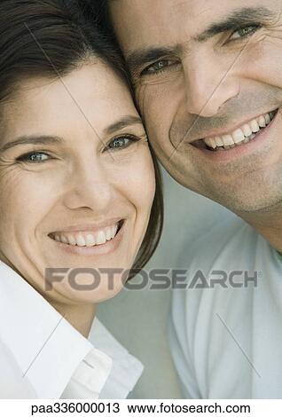 Stock Image - Couple cheek to cheek, smiling, front view, close-up. Fotosearch