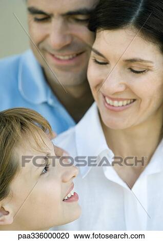 Stock Image - Family with one child, mother and daughter looking at each other, smiling, close-up. Fotosearch
