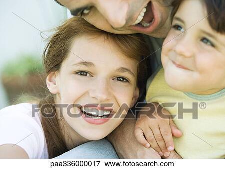 Father embracing his two chidren, all smilling, close-up View Large Photo Image Stock Photo - Father embracing his two chidren, all smilling, close-up. Fotosearch