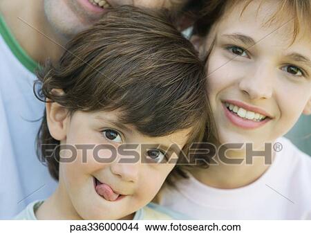 Father with two children, boy sticking out tongue, girl and father smiling, portrait, extreme close-up View Large Photo Image Picture - Father with two children, boy sticking out tongue, girl and father smiling, portrait, extreme close-up. Fotosearch