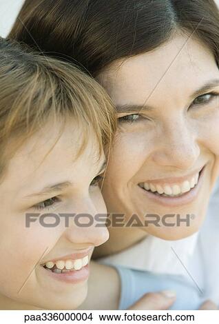 Picture - Mother embracing her daughter, both smiling, close-up. Fotosearch