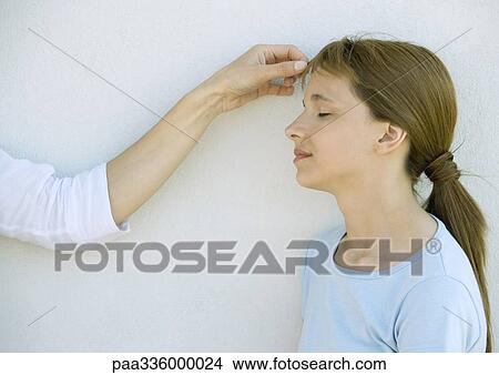Mother touching her daughter 's forehead, closed eyes and slightly smiling View Large Photo Image Picture - Mother touching her daughter 's forehead, closed eyes and slightly smiling. Fotosearch