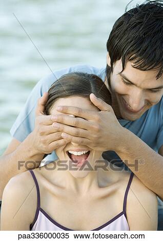 Young man covering his girlfriend's eyes, both laughing, portrait, close-up View Large Photo Image Stock Photography - Young man covering his girlfriend's eyes, both laughing, portrait, close-up. Fotosearch