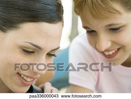 Young woman and girl looking down and smiling, portrait, extreme close-up View Large Photo Image Stock Image - Young woman and girl looking down and smiling, portrait, extreme close-up. Fotosearch