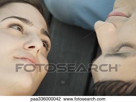 Young woman reclining on the ground, looking at her boyfriend upside down, smiling, portrait, extreme close-up View Large Photo Image Stock Image - Young woman reclining on the ground, looking at her boyfriend upside down, smiling, portrait, extreme close-up. Fotosearch
