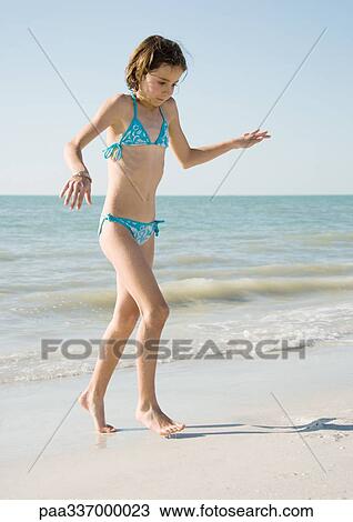 Girl on beach, walking away from water on tiptoes View Large Photo Image Stock Image - Girl on beach, walking away from water on tiptoes. Fotosearch