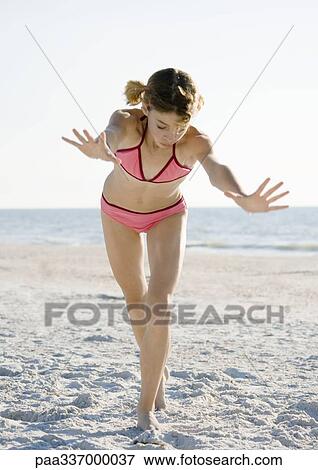 Stock Photo - Girl starting cartwheel on beach. Fotosearch