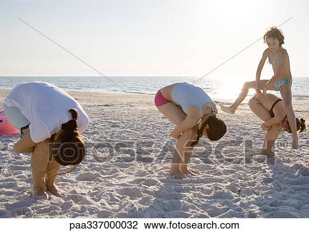 Girls playing leapfrog on beach View Large Photo Image Stock Image - Girls playing leapfrog on beach. Fotosearch