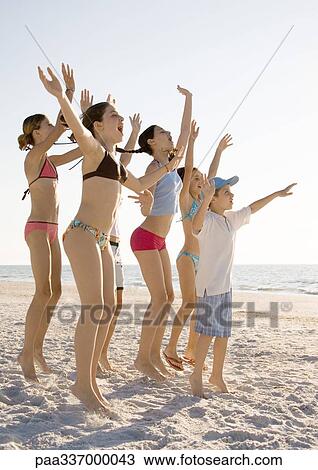 Group of kids jumping and waving on beach View Large Photo Image Stock Image - Group of kids jumping and waving on beach. Fotosearch