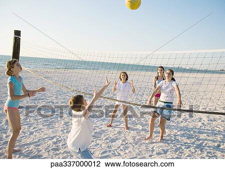 Stock Image - Group of kids playing beach volleyball. Fotosearch
