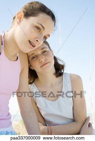 Stock Photo - Two preteen girls, one leaning head on other's shoulder. Fotosearch