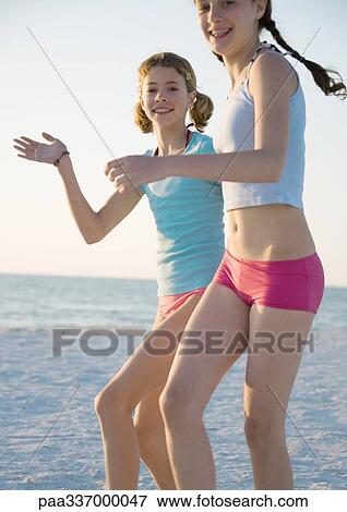 Stock Photo - Two preteen girls running on beach. Fotosearch
